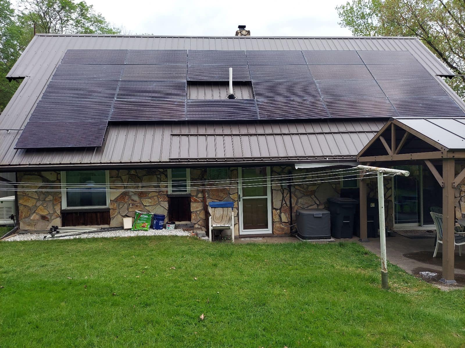 Residential home with solar panels installed among surrounding trees